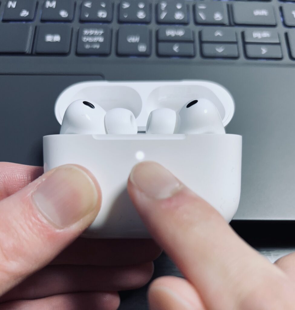 AirPods Pro 3 のペアリングモードを開始。ケース前面のLEDランプが白く点灯している様子。