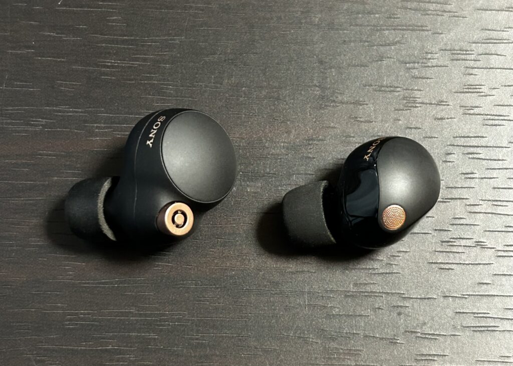 WF-1000XM4 と WF-1000XM5 のイヤホン本体正面比較。「M5」は小型化とデザイン変更が施されている。