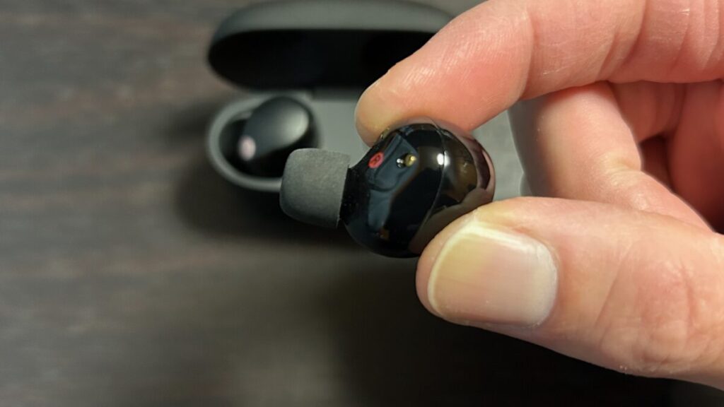 WF-1000XM5の光沢部分を指でつまんでいる様子。ツートン仕上げの光沢部は滑りやすい場合がある。