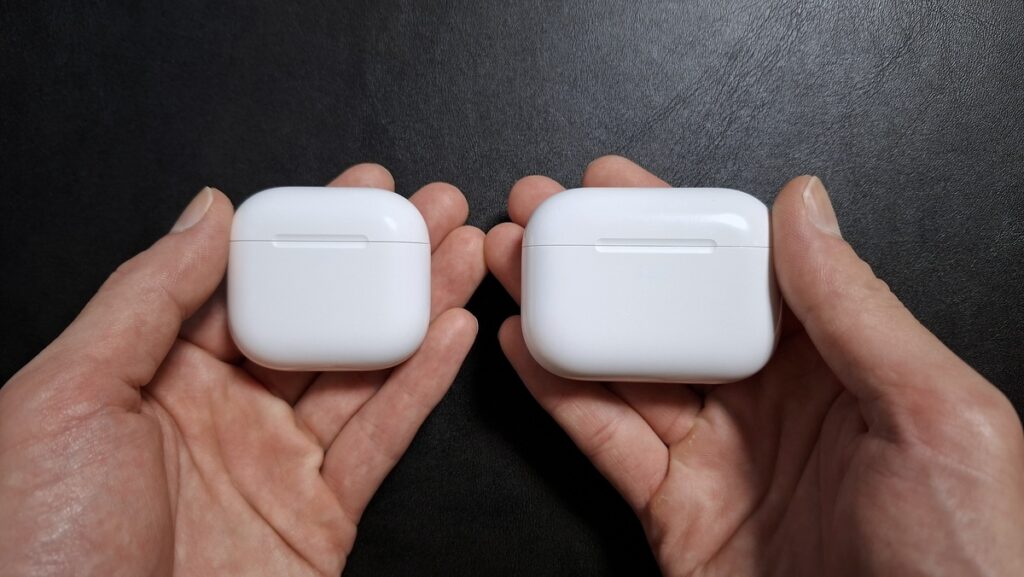 AirPods 5（左）とAirPods Pro 3（右）の充電ケースを両手に持って重さを比べている様子