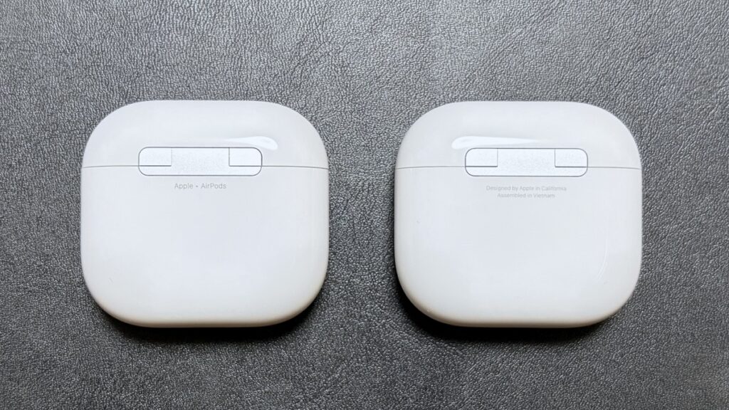 AirPods 5（左）とAirPods 4（右）の充電ケース背面比較。ヒンジ下の印字がAirPods 5は「Apple・AirPods」に変更